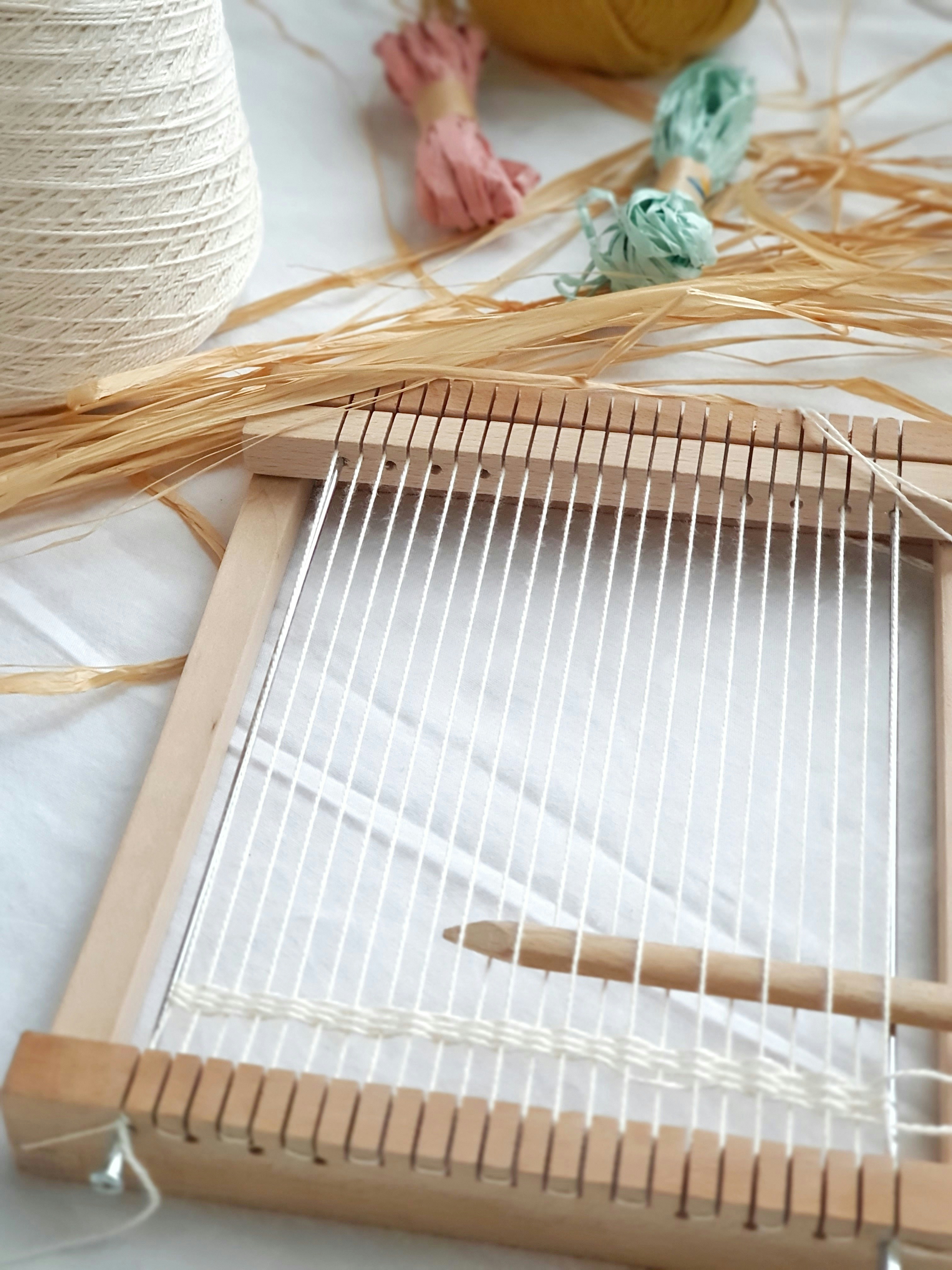 A traditional weaving loom with colourful threads and yarn spools — the EVP as the bobbin drawing the strands of employee experience together